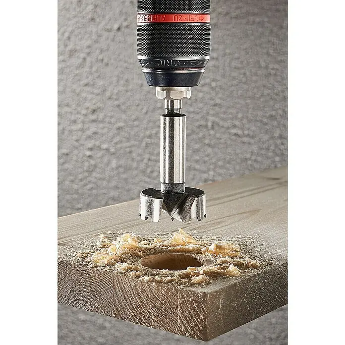 Wolfcraft Forstnerbohrer - Durchmesser Bohrer: 40 mm - Forstnerbohrer im Einsatz: Ein Forstnerbohrer bohrt ein sauberes Loch in ein Holzbrett, umgeben von Holzspänen.