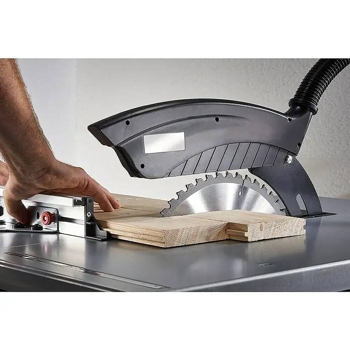 Wolfcraft Kreissägeblatt Serie lila - 315 mm, Bohrung: 30 mm, Anzahl Zähne: 48 Stk. - Eine Tischkreissäge schneidet ein Holzbrett, wobei die Hand des Bedieners in der Nähe des Werkstücks zu sehen ist.\n