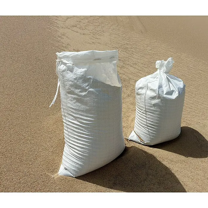Gewebesack - 60 x 40 cm, Polypropylen, 10 Stk. - Zwei weiße Sandsäcke unterschiedlicher Größe stehen auf einer sandigen Oberfläche. Sie scheinen mit Sand gefüllt zu sein und werfen Schatten.