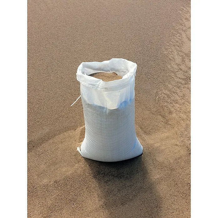 Gewebesack - 60 x 40 cm, Polypropylen, 10 Stk. - Nahaufnahme eines gefüllten Sandsacks im Freien, der das Gewicht und die Textur des Inhalts betont.