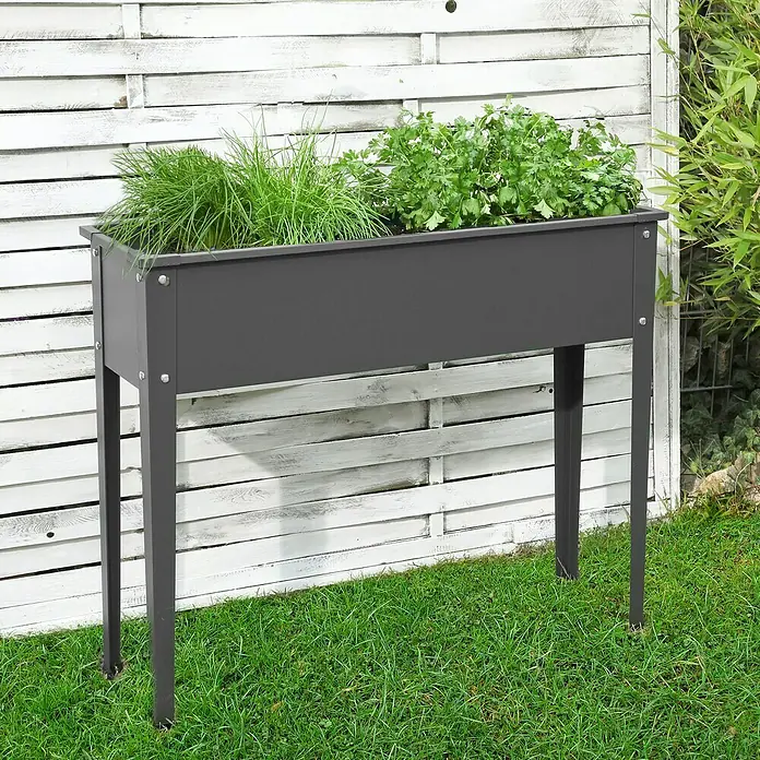 Floraworld Hochbeet - 80 x 100 x 40 cm, Metall, Anthrazit - Grauer Hochbeet-Pflanzkasten mit Kräutern, perfekt für den Garten oder die Terrasse, vor einem weißen Holzzaun platziert.