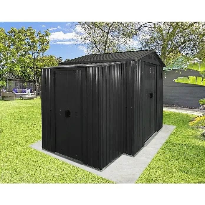 Floraworld Anbauschrank - Passend für: floraworld Gerätehäuser mit Sattel- oder Pultdach - Eine moderne, anthrazitfarbene Metallgartenhütte mit Doppeltür und Anbaudach auf einer Betonterrasse im gepflegten Garten.