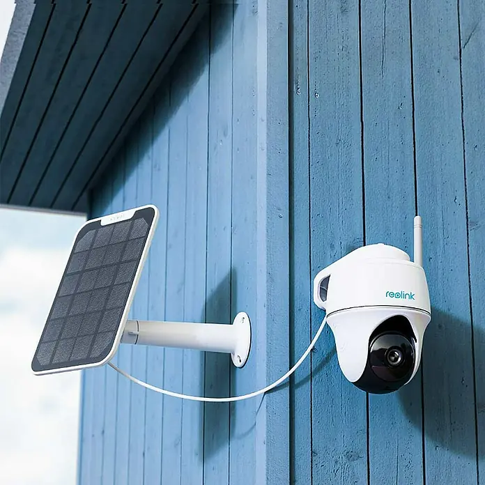 Reolink Akku-Überwachungskamera ARGUS SERIES B420 -  - Bild einer Reolink Überwachungskamera mit Solarpanel an einer blauen Holzwand befestigt, die für nachhaltige Sicherheit sorgt.