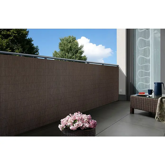 Gardol Sichtschutz - 3 x 0,9 m, Dunkelbraun - Ein Balkon mit einem braunen Sichtschutz, einem Tisch mit Geschirr und Blumen. Perfekt für entspannte Stunden im Freien.