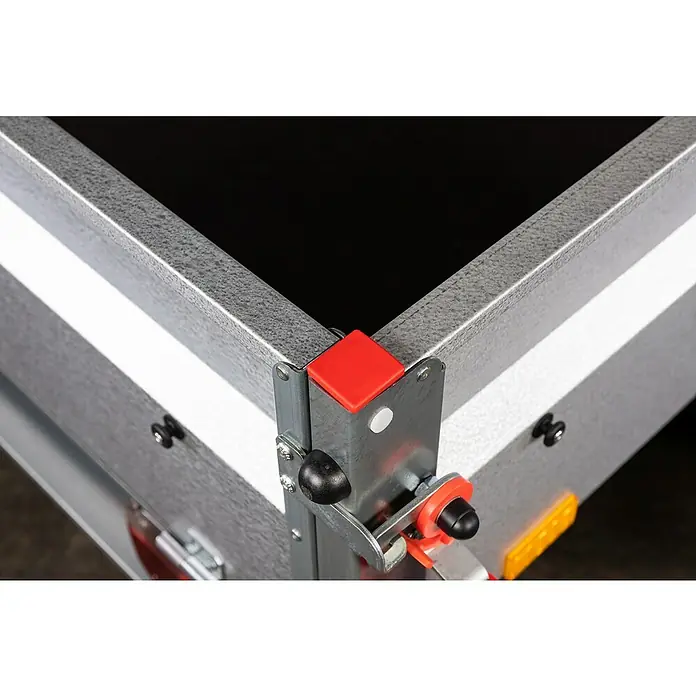 Stema Anhänger BASIC 750 Kippdeichsel - Nutzlast: 615 kg, Einachser, 201 x 108 x 33 cm, Ungebremst - Detailansicht einer Anhängerecke mit Metalleinfassung und rotem Eckschutz, die die robuste Bauweise und das durchdachte Design hervorhebt.