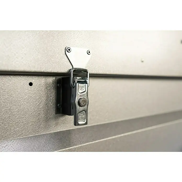 Stema Anhänger BASIC 750 mit Metalldeckel - Nutzlast: 575 kg, Einachser, Kasteninnenmaß: 201 x 108 x 47 cm, Ungebremst - Nahaufnahme eines stabilen, verchromten Kastenschlosses an einer grauen Metalltür, das Sicherheit und Funktionalität vereint.
