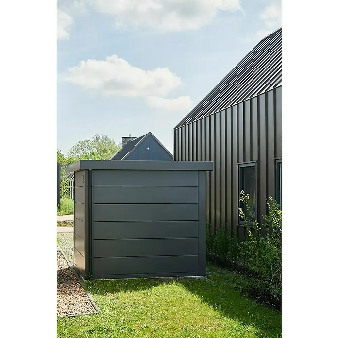 Telluria Metallgerätehaus Classico 2424 - Außenmaß inkl. Dachüberstand (B x T): 258 x 258 cm, Stahl, Anthrazit, Ohne Set - Ein moderner, anthrazitfarbener Gerätehaus im Außenbereich neben einem Haus mit vertikalen Metallpaneelen. Praktische und stilvolle Aufbewahrung.