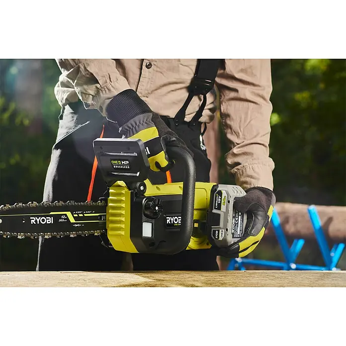 Ryobi ONE+HP Akku-Kettensäge RY18CSX30A-150 Whisper - 18 V, Li-Ionen, 1 Akku, Schwertlänge: 30 cm - Nahaufnahme einer RYOBI Akku-Kettensäge mit 18V Akku, gehalten von einer Person mit Arbeitshandschuhen.