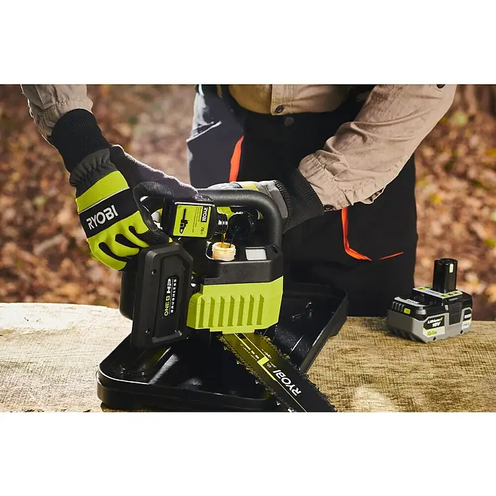 Ryobi ONE+HP Akku-Kettensäge RY18CSX30A-150 Whisper - 18 V, Li-Ionen, 1 Akku, Schwertlänge: 30 cm - Ein Mann füllt Öl in eine Ryobi Akku-Kettensäge. Die Kettensäge ist grün und schwarz. Akku ist auch sichtbar.