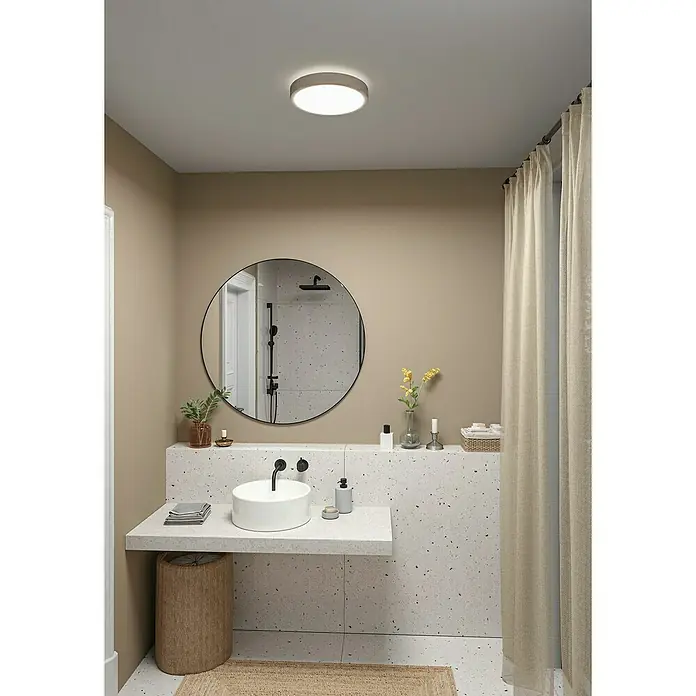Paulmann LED-Panel rund Cosara - 15 W, Ø x H: 30 x 6,2 cm, Beige, Neutralweiß - Badezimmer mit runden Spiegel über Aufsatzwaschbecken auf Terrazzo-Waschtisch. Die Deckenleuchte sorgt für angenehmes Licht.