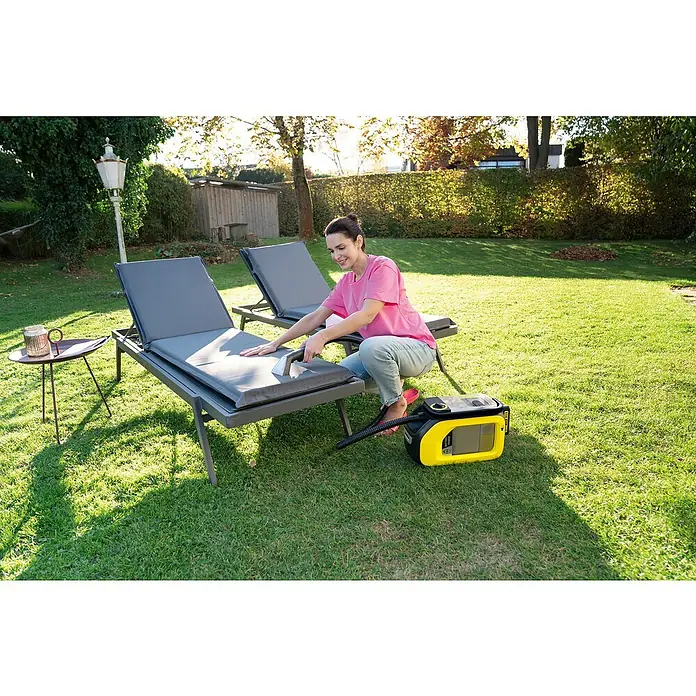 Kärcher Akku-Waschsauger SE 3-18 Compact - 18 V, Ohne Akku, 2,5 Ah - Frau reinigt Terrassenmöbel mit einem gelben Kärcher Waschsauger, um sie sauber und ordentlich zu halten.