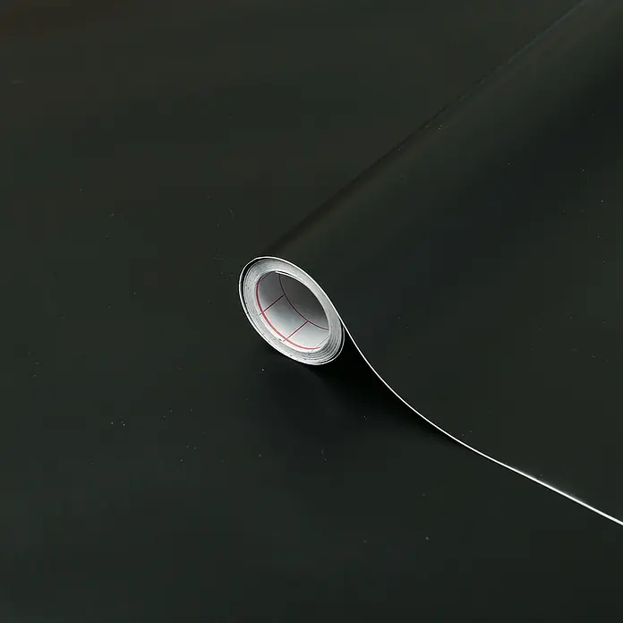D-c-fix Klebefolie Uni Seidenmatt - 200 x 45 cm, Schwarz, Selbstklebend - Nahaufnahme einer Rolle schwarzer, selbstklebender Vinylfolie, ideal für Bastelprojekte und zur Dekoration von Oberflächen.