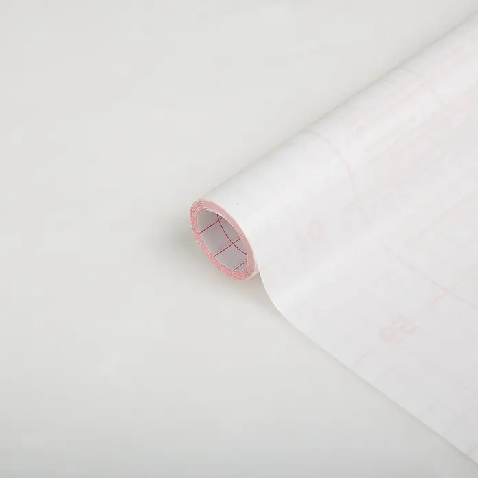 D-c-fix Glasfolie Opal - 200 x 45 cm, Transluzent, Selbstklebend - Ein aufgerolltes Blatt weißes, transparentes Papier mit rotem Rastermuster liegt auf einer weißen Oberfläche. Ideal für Bastelprojekte und Design.