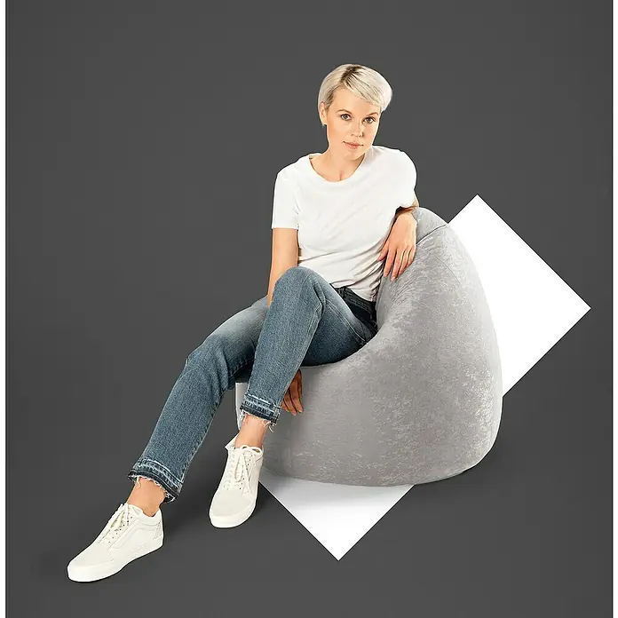 Sitting Point Sitzsack Beanbag Easy - XL, Grau, 100 % Polyester - Eine Frau sitzt entspannt auf einem grauen Sitzsack, der sich durch sein angenehmes Material und modernes Design auszeichnet.