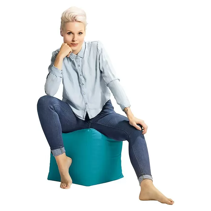 Sitting Point Sitzhocker Cube Scuba - 40 x 40 x 40 cm, Petrol, 100 % Polyester - Frau sitzt auf einem weichen, türkisen Stoff-Pouf und demonstriert sein bequemes Design.