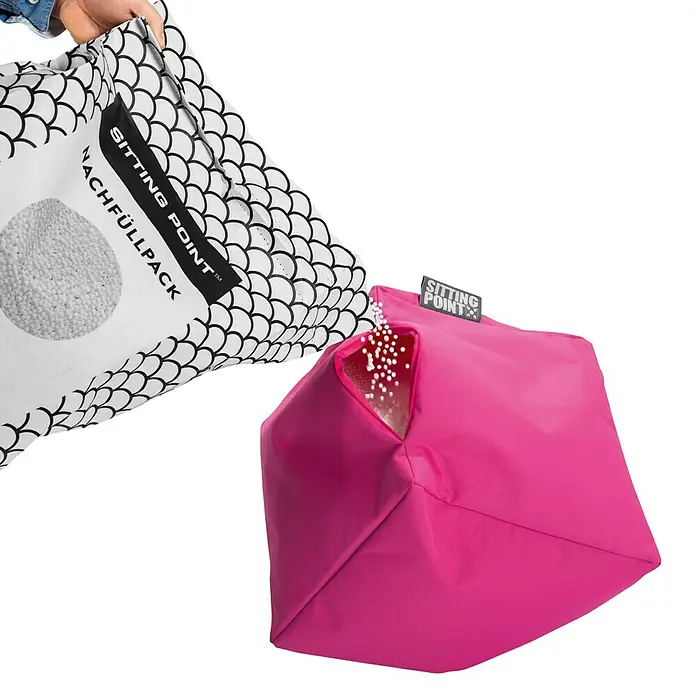 Sitting Point Polystyrolkugel Nachfüllpack - 60 l, Weiß - Das Bild zeigt das Nachfüllen eines pinkfarbenen Sitzsacks von Sitting Point mit Füllmaterial aus einem Nachfüllpack.