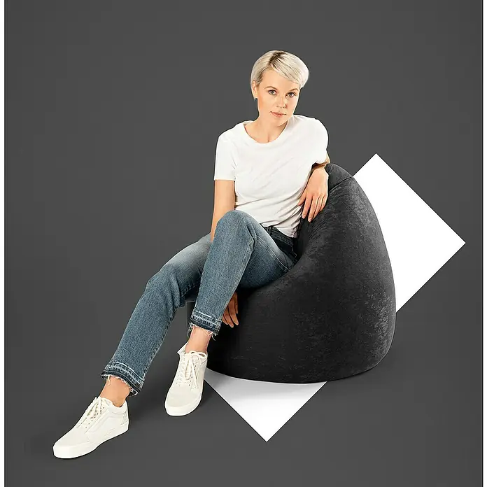 Sitting Point Sitzsack Beanbag Easy - XL, Schwarz, 100 % Polyester - Eine Frau sitzt entspannt auf einem schwarzen Sitzsack. Der Sitzsack ist bequem und lädt zum Verweilen ein, ideal für gemütliche Stunden.