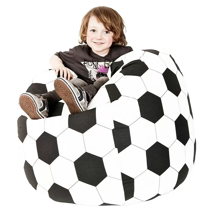 Sitting Point Sitzsack Beanbag Fußball - XL, Schwarz/Weiß, 100 % Baumwolle - Lächelndes Kind sitzt bequem in einem großen schwarz-weißen Fußball-Sitzsack.