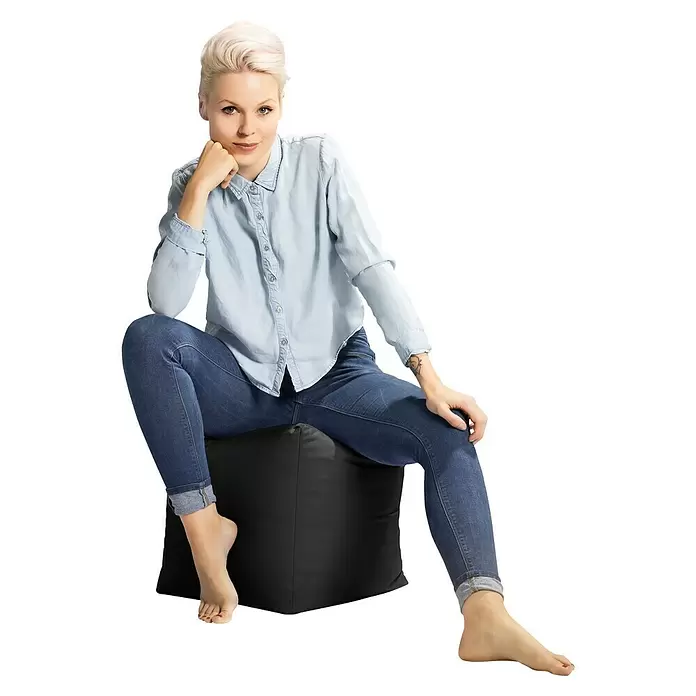 Sitting Point Sitzhocker Cube Scuba - 40 x 40 x 40 cm, Schwarz, 100 % Polyester - Schwarzer Würfel-Pouf, von einer Frau als bequemer Sitz genutzt. Kompaktes Design.