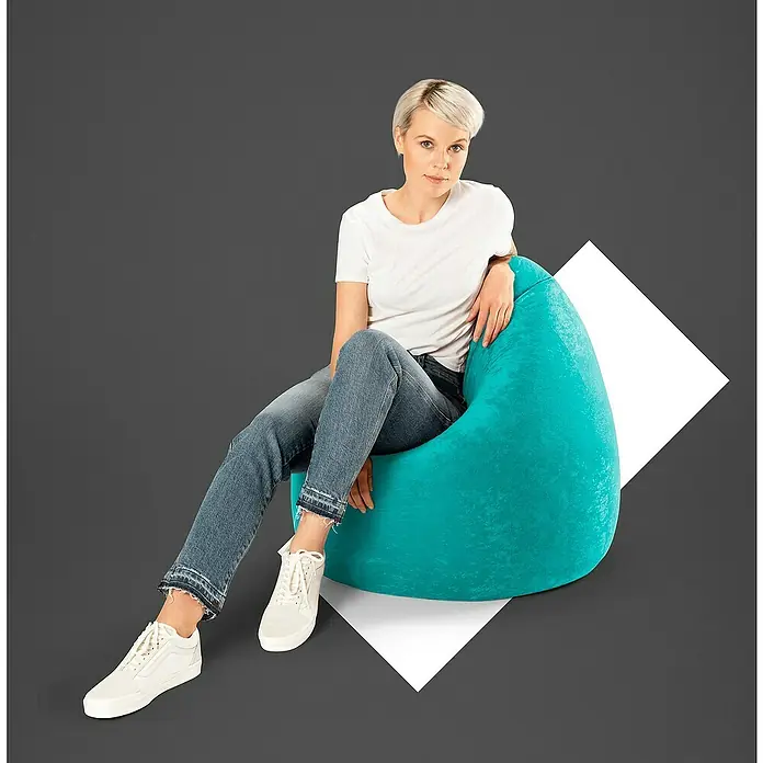 Sitting Point Sitzsack Beanbag Easy - XL, Smaragd, 100 % Polyester - Frau sitzt entspannt auf einem türkisfarbenen Sitzsack, der eine gemütliche und stilvolle Ergänzung für jeden Wohnraum darstellt.