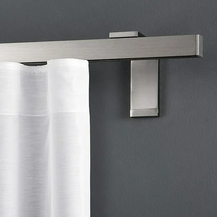 Expo Ambiente Wandträger Smart - Silber, Länge: 11,5 cm - Detailaufnahme einer Gardinenstange aus gebürstetem Nickel mit einer weißen, transparenten Gardine. Die Stange ist quadratisch mit Halterung.