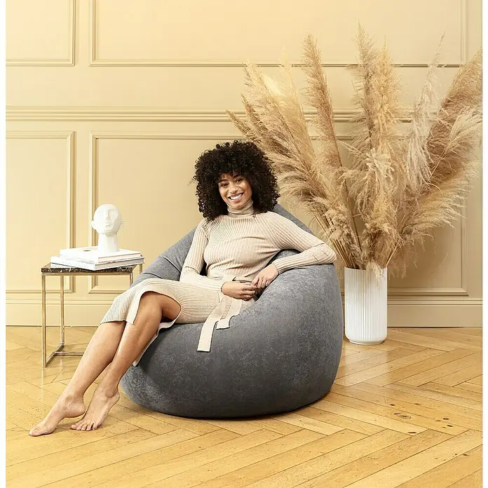 Sitting Point Sitzsack Beanbag Easy - XL, Altrose, 100 % Polyester - Eine Frau sitzt entspannt in einem grauen Sitzsack. Der bequeme Sitzsack bietet Komfort und Stil für jeden Raum.