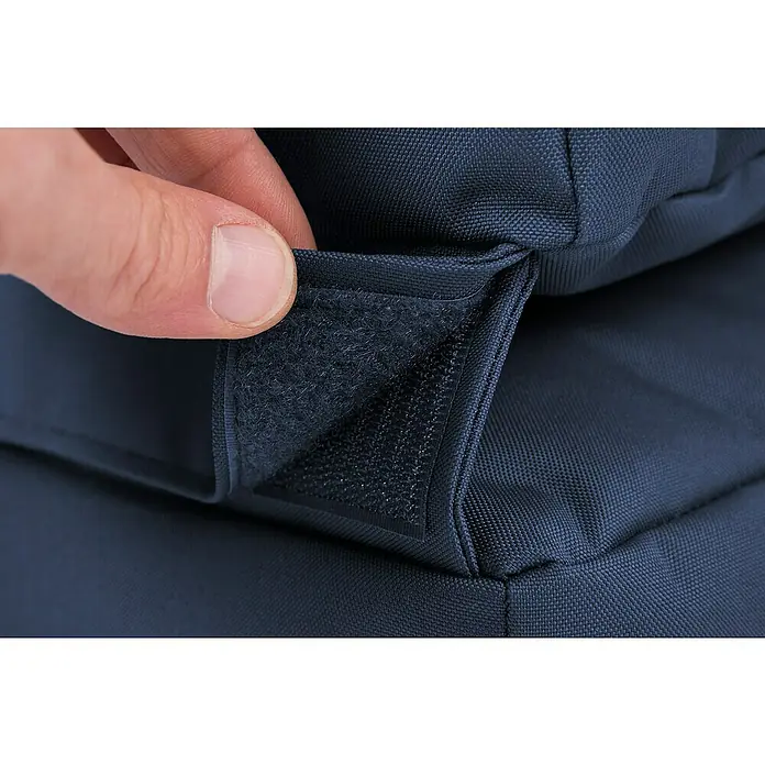 Sitting Point Sitzsack Twist Scuba - 90 x 70 x 80 cm, Jeansblau, 100 % Polyester - Nahaufnahme eines Rucksacks mit einem Klettverschluss, der von einer Hand geöffnet wird, der Verschluss ist dunkelblau.