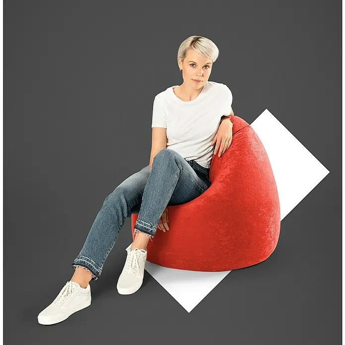 Sitting Point Sitzsack Beanbag EasyXL, Tomate, 100 % Polyester - Frau sitzt in einem roten Sitzsack und trägt ein weißes T-Shirt, Jeans und weiße Sneaker.
