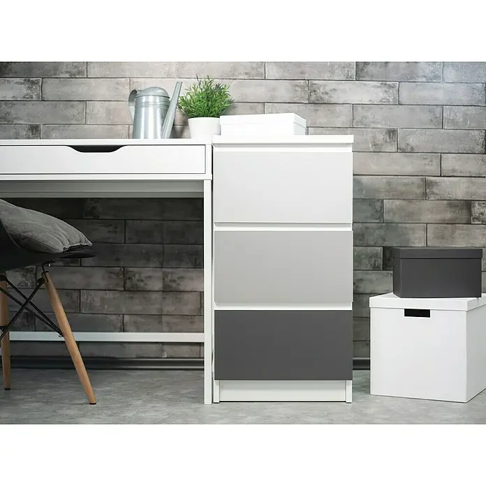 D-c-fix Klebefolie Uni Seidenmatt - 210 x 90 cm, Grau, Selbstklebend - Ein modernes Möbelstück mit einem weißen Schreibtisch und einer Kommode mit grau abgestuften Schubladen, ideal für ein stilvolles Arbeitszimmer.
