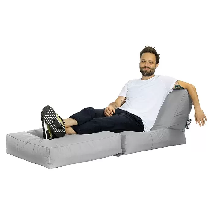 Sitting Point Sitzsack Twist Scuba - 90 x 70 x 80 cm, Grau, 100 % Polyester/100 % Polyvinylchlorid - Hellgrauer modularer Sitzsack-Loungesessel mit einem darauf entspannenden Mann.