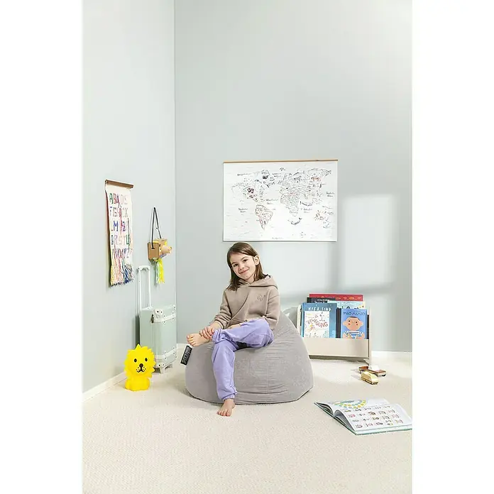 Sitting Point Sitzsack Beanbag Easy - L, Grau, 100 % Polyester - Ein grauer Sitzsack, auf dem ein Mädchen sitzt, in einem Kinderzimmer mit Büchern, Spielzeug und einer Weltkarte an der Wand.