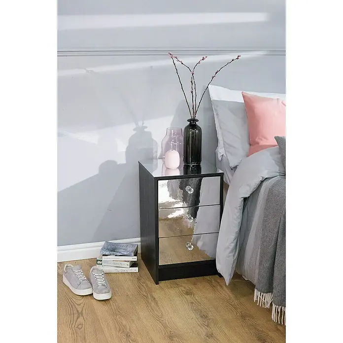 D-c-fix Klebefolie Spiegeleffektfolie - 120 x 90 cm, Spiegeleffekt, Selbstklebend - Nachttisch mit Spiegeldetails und drei Schubladen, dekoriert mit Vasen und Büchern, neben einem Bett und Schuhen.
