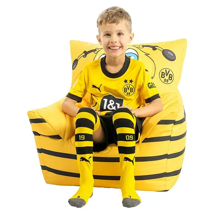 Sitting Point Sitzsack VIP Kids Sessel - 50 x 50 cm, BVB Emma, 100 % Polyester - Lächelnder Junge in gelb-schwarzer BVB 09 Fußballkleidung und passenden Socken, auf einem gelb-schwarz gestreiften Sitzsack sitzend.