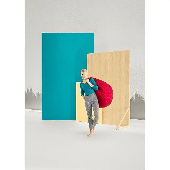 Sitting Point Sitzsack Beanbag Easy - XL, Rot, 100 % Polyester - Eine Frau mit einem roten Sitzsack über der Schulter, posiert vor farbigen geometrischen Formen. Der Sitzsack ist das Hauptprodukt.