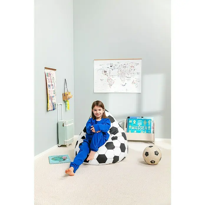 Sitting Point Sitzsack Beanbag Fußball - L, Schwarz/Weiß, 100 % Baumwolle - Mädchen entspannt im Kinderzimmer auf einem Fußball-Sitzsack, umgeben von Büchern und Spielzeug. Der Sitzsack ist das perfekte Möbelstück für Kinder.