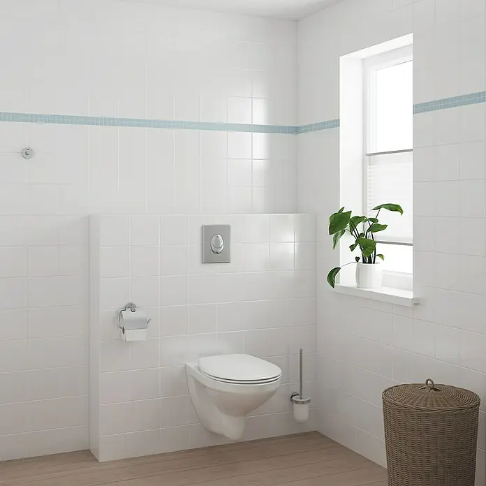 Grohe Essentials WC-Set 3in1 - 3 -tlg., Chrom, Glänzend - Badezimmer-Szene mit einer wandmontierten Toilette, einem Fenster mit Jalousie und einer grünen Pflanze. Das Design ist minimalistisch und sauber.
