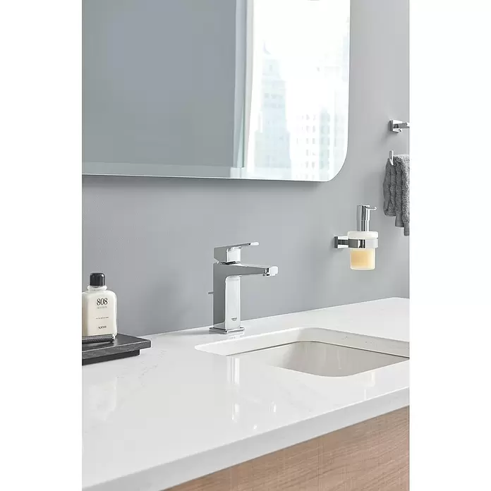 Grohe Essentials Cube Dispensador de jabón - Cromo - Grifo de baño cromado moderno sobre un tocador de mármol blanco con lavabo integrado en un entorno contemporáneo.
