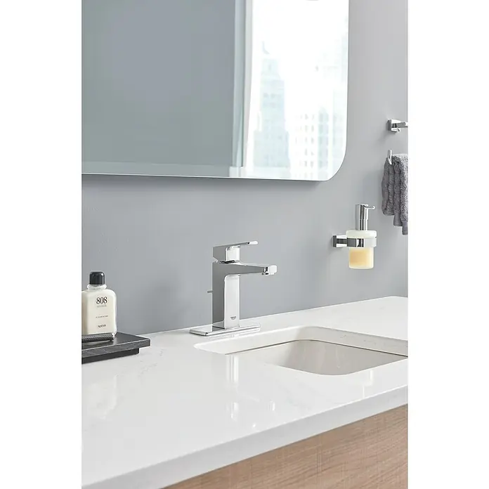 Grohe Essentials Cube Seifenspender - Mit Halterung, Chrom, Glänzend - Nahaufnahme einer modernen Badezimmerarmatur von Grohe, die elegantes Design und hochwertige Verarbeitung vereint, mit Seifenspender und Spiegel.