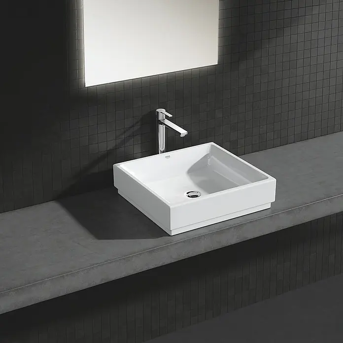 Grohe Lineare Waschtischarmatur XL-Size - Chrom, Glänzend - Elegantes, quadratisches Aufsatzwaschbecken in Weiß mit einer modernen Armatur, stilvoll präsentiert auf einer grauen Waschtischplatte.