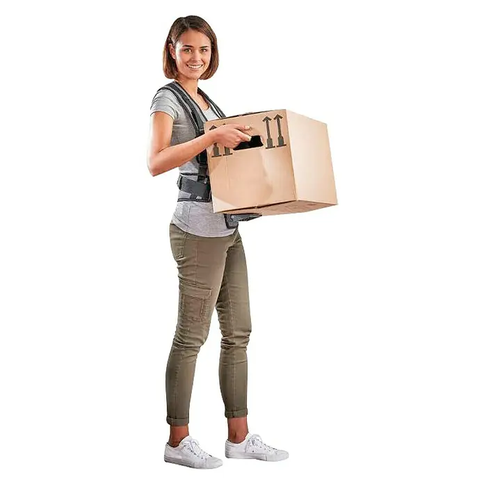 Wolfcraft Faja lumbar de transporte - Negro, Capacidad de carga: 30 kg - Mujer con un arnés de soporte de carga que la ayuda a llevar una caja de cartón más fácilmente. Ella está sonriendo a la cámara.