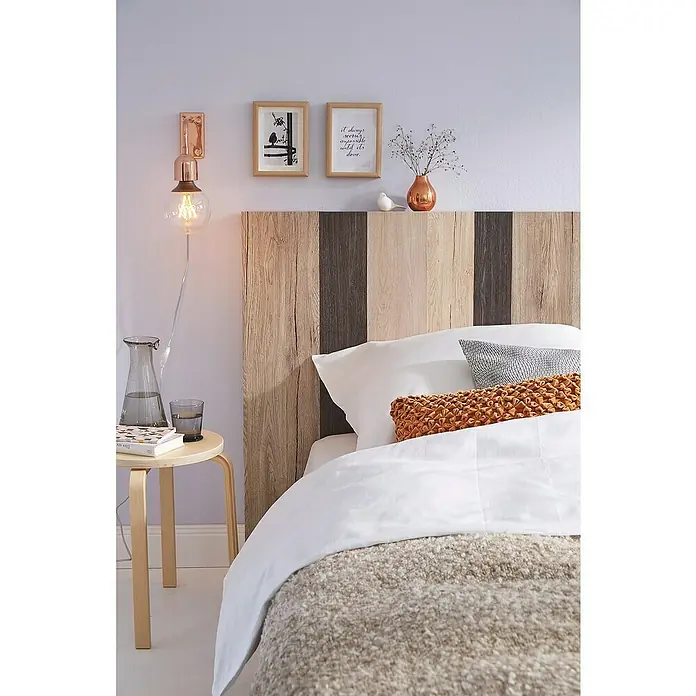 D-c-fix Holzoptikfolie Santana Eiche - 210 x 90 cm, Kalk, Selbstklebend - Stilvolles Schlafzimmer mit einem Bett, das mit einer weichen Decke, Kissen und einem einzigartigen Holzkopfteil ausgestattet ist.
