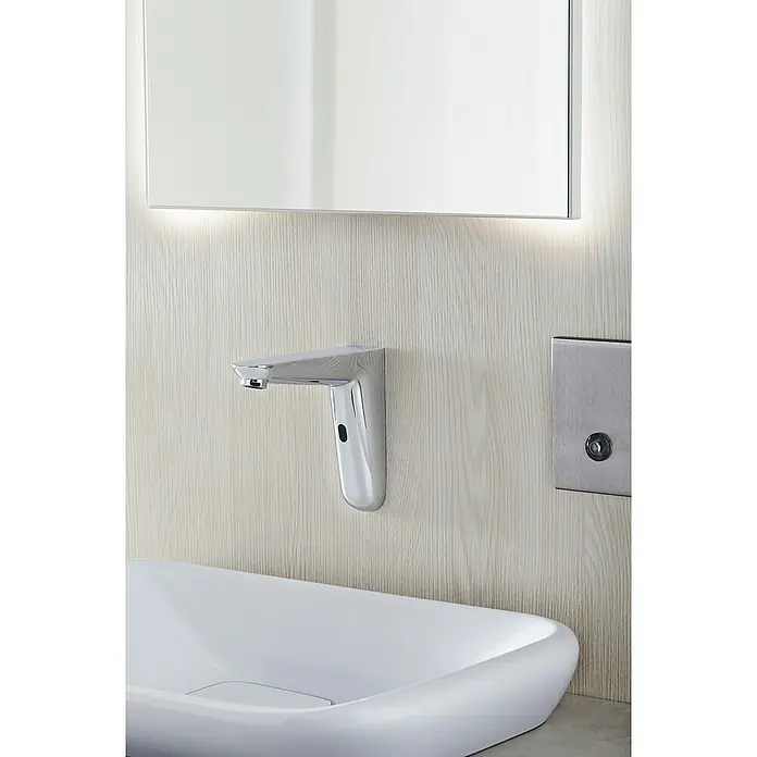 Grohe Euroeco CT Waschtischarmatur - Infrarot-Elektronik, Chrom, Glänzend, Ausladung: 170 mm - Nahaufnahme eines modernen Badezimmers mit einem eleganten, automatischen Wasserhahn und einem stilvollen Waschbecken vor einem beleuchteten Spiegel.