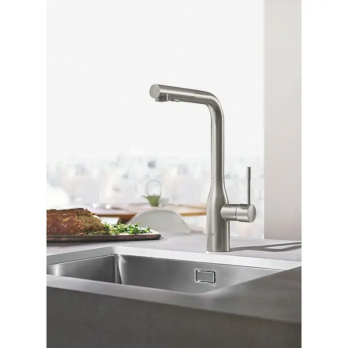 Grohe Essence Spültischarmatur - L-Auslauf, Supersteel, Matt - Nahaufnahme einer eleganten, gebürsteten Küchenarmatur von Grohe an einer modernen Spüle mit Brot im Hintergrund.