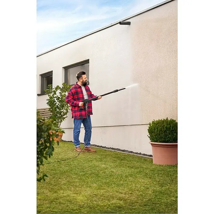 Kärcher Strahlrohr eco!Booster 130 - Passend für: Kärcher Hochdruckreiniger der Klassen K4, 615 x 108 x 51 mm - Mann reinigt mit einem Hochdruckreiniger eine Hauswand. Das Gerät entfernt mühelos Schmutz und sorgt für ein sauberes Ergebnis.