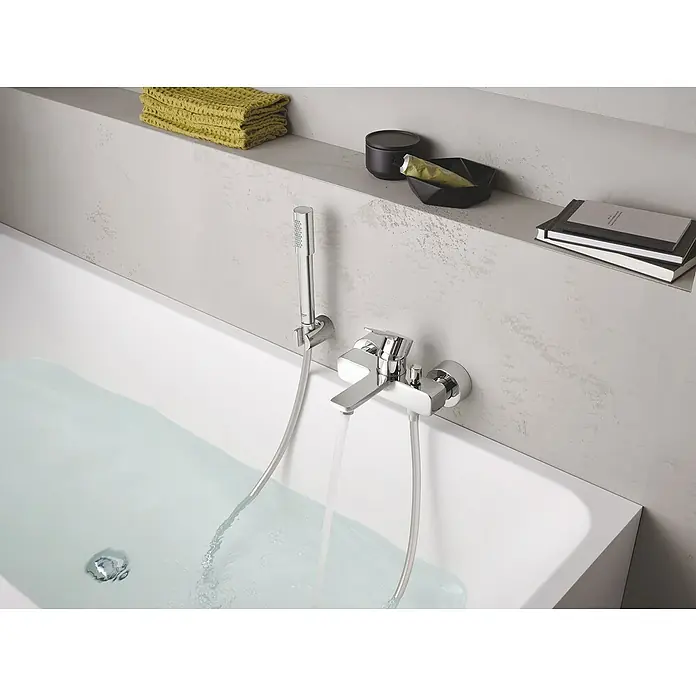 Grohe Lineare Badewannenarmatur - Ausladung Armatur: 184 mm, Chrom, Glänzend - Moderne Badewanne mit Chromarmatur und Handbrause. Das Wasser läuft in die Wanne, während auf dem Regal Handtücher und Badutensilien liegen.