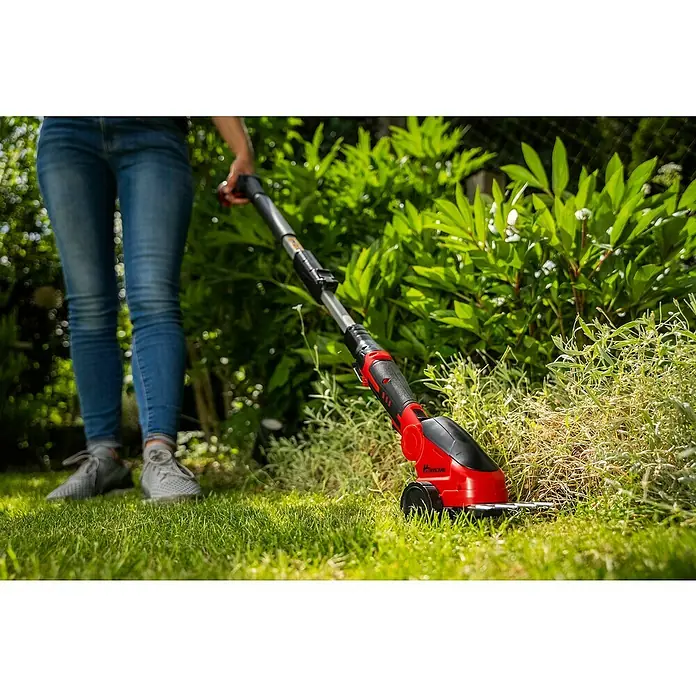 Hurricane Akku-Gras- & Strauchschere HGS-I-120 - 12 V, Li-Ionen, 1 Akku - Eine Person benutzt eine rote und schwarze Hurricane Akku-Grasschere mit Teleskopstiel im Garten, um Rasen zu trimmen.