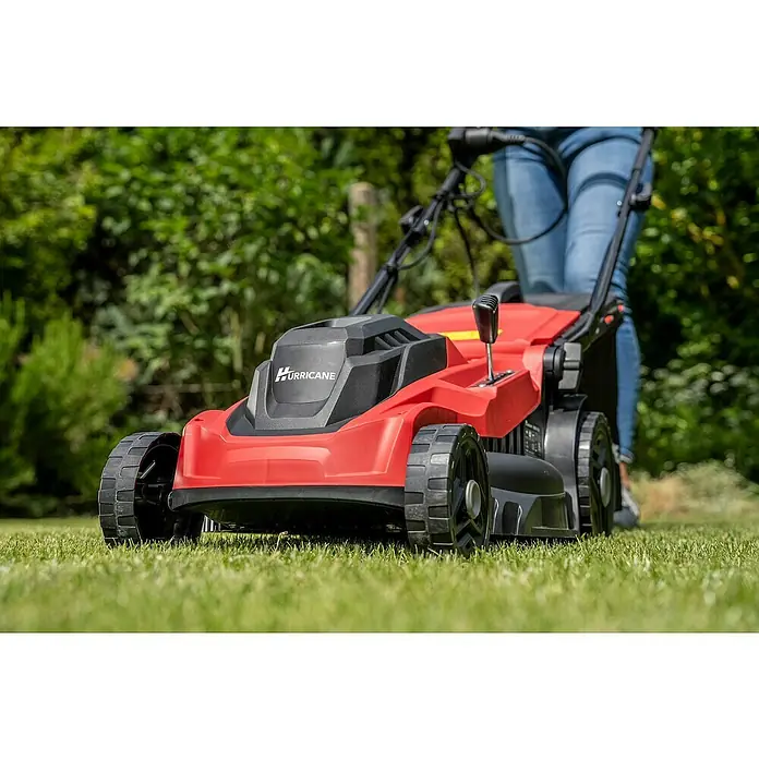 Hurricane Elektro-Rasenmäher HERM-I-1638 - 1.600 W, Schnittbreite: 38 cm - Nahaufnahme eines roten Hurricane-Rasenmähers auf einem Rasen, bedient von einer Person mit Jeans.