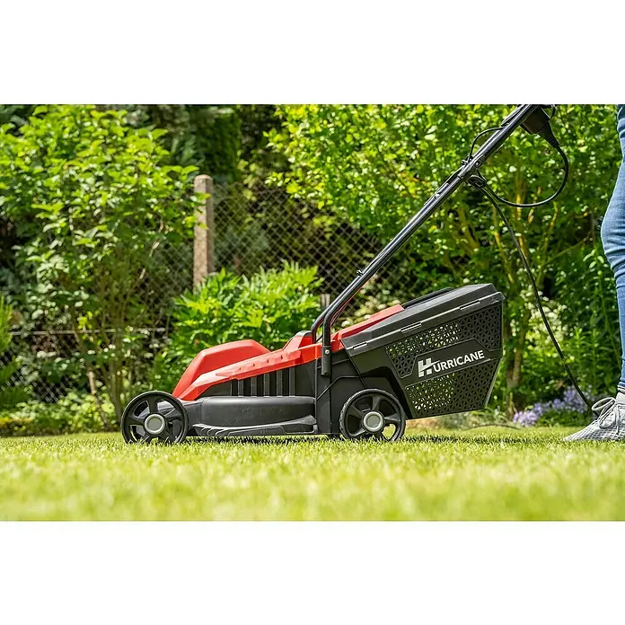 Hurricane Elektro-Rasenmäher HERM-I-1232 - 1.200 W, Schnittbreite: 32 cm - Ein roter und schwarzer Hurricane-Rasenmäher steht auf einem grünen Rasen vor einem Garten. Perfekt für die Rasenpflege.