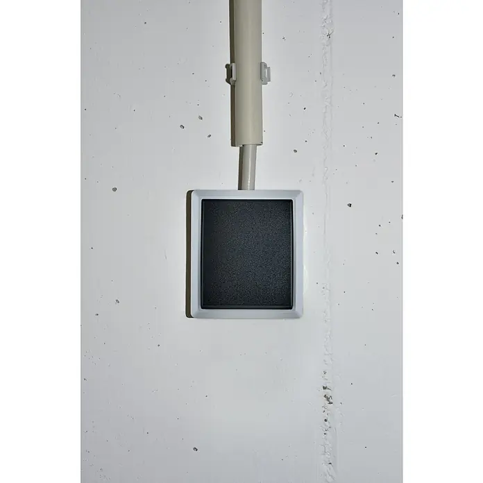 Aqua Form Feuchtraum-Kontrollschalter - Grau, Aufputzmontage, IP44 - Schwarzer quadratischer Lichtschalter mit weißem Rahmen und grauer Kabelabdeckung an einer weißen Wand montiert.