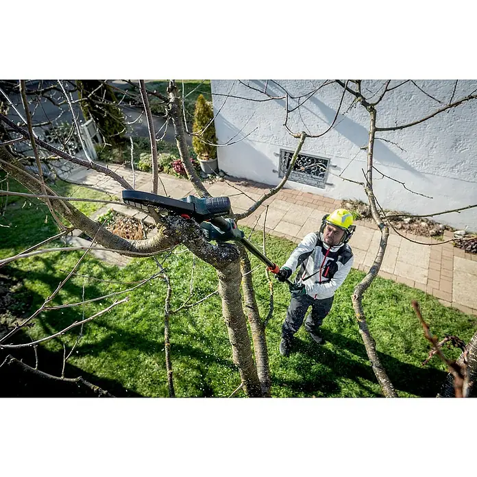 Metabo Teleskopstab MS - Passend für: Akku-Gehölzsäge MS 18 LTX 15 - Ein Mann schneidet mit einer Metabo Hochentaster einen Baum. Der Hochentaster ist gut sichtbar und im Fokus des Bildes.